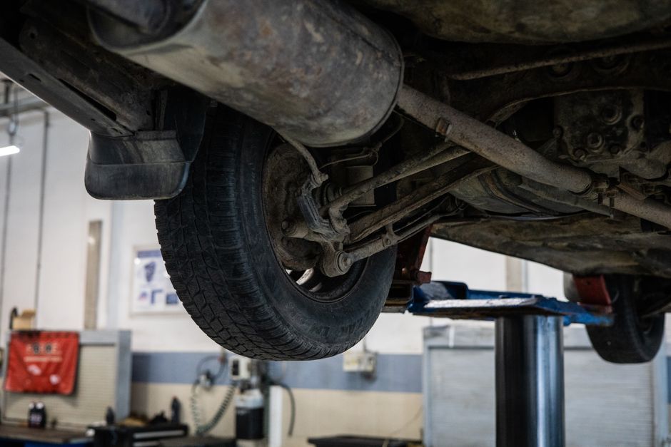 Technician installing a car wheel with precision tools