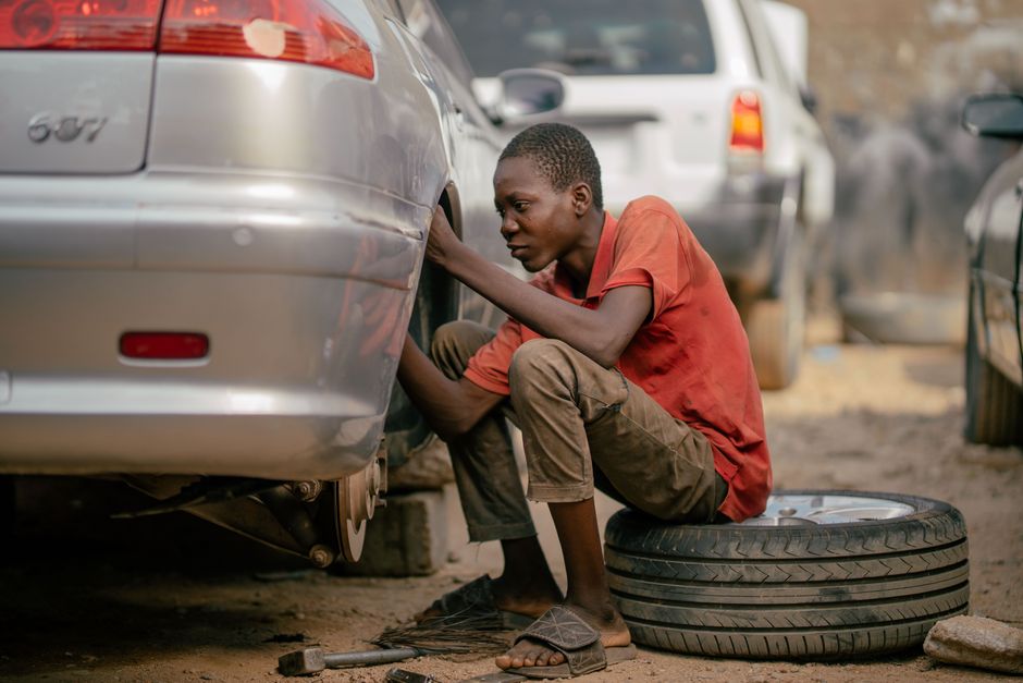 Professional mechanic changing a car tire in a clean garage